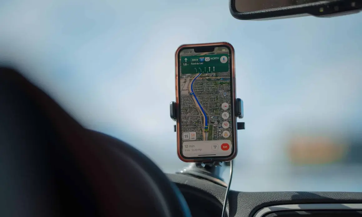 A smartphone with GPS navigation app mounted on a car dashboard during a road trip, cws marketing centennial square